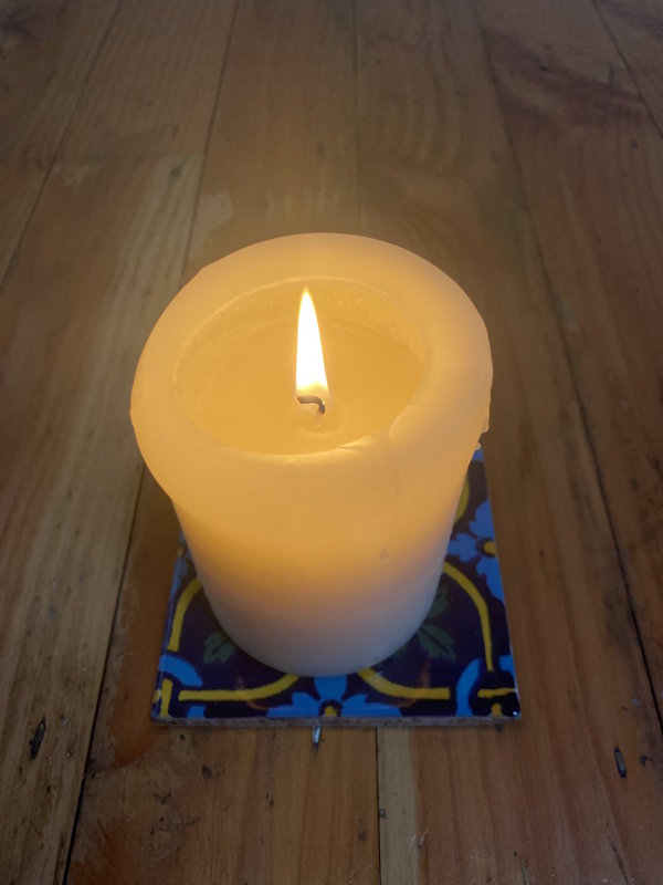 A lit candle symbolizing memory and sanctuary